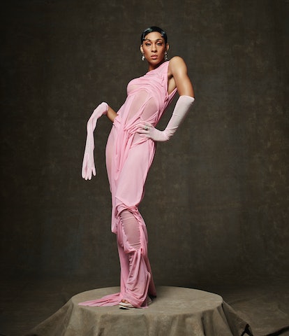 Actor Michaela Jaé Rodriguez stands on a platform while wearing a light pink, floor-length gown and ...