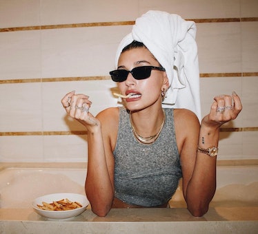 Hailey Bieber eating fries in towel and sunglasses